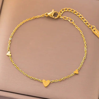 Arany színű láncos női karkötő három kis szív medállal